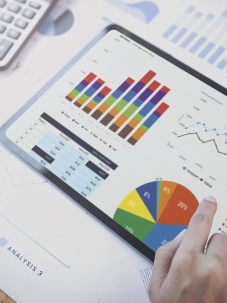 Businesswoman using a tablet to analysis graph company finance strategy statistics success concept and planning for future in office room.