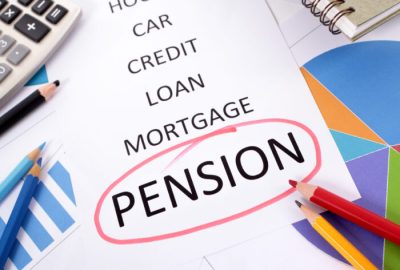 The word Pension circled in red with a list of saving and debt obligations surrounded by graphs, charts, books and pencils.